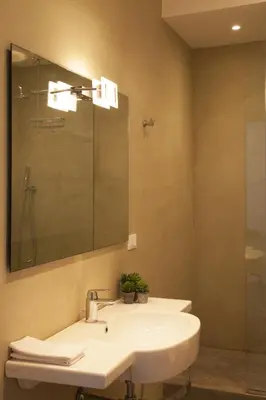a bathroom with a white sink and a mirror at Rosalmar B&B in Palermo