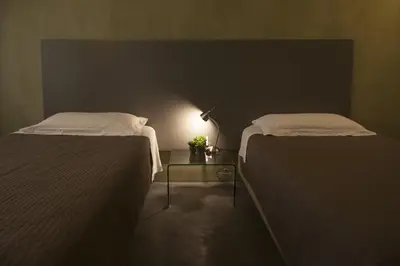 a room with two beds and a table with a lamp at Rosalmar B&B in Palermo