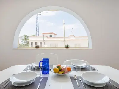a table with a bowl of fruit and an arch window at Apartment Pietra Marina by Interhome in Balestrate