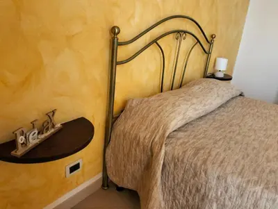 a bedroom with a bed with a wooden wall at Granello di Sabbia in San Vito lo Capo
