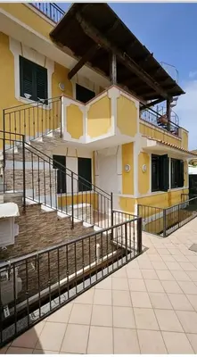 a building with stairs in front of a house at Casa Marina in Isola delle Femmine