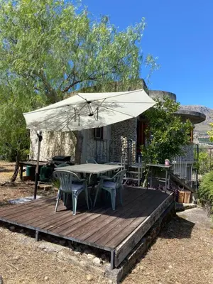 a wooden deck with a table and an umbrella at Holiday Green in Carini