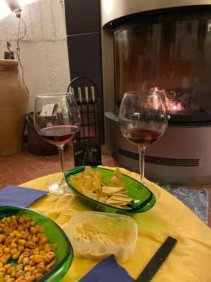 a table with two glasses of wine and a plate of food at Holiday Green in Carini
