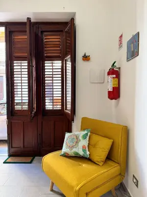 a yellow couch with a pillow on it in a room at mamali in Terrasini