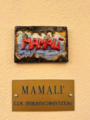 a sign for a man mall on a wall at mamali in Terrasini
