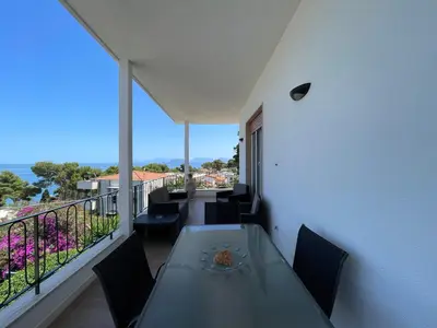 a dining table on a balcony with a view of the ocean at Appartanvilla Magellano in Mondello