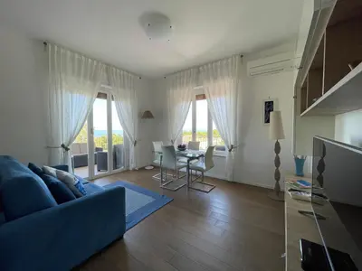 a living room with a blue couch and a table at Appartanvilla Magellano in Mondello