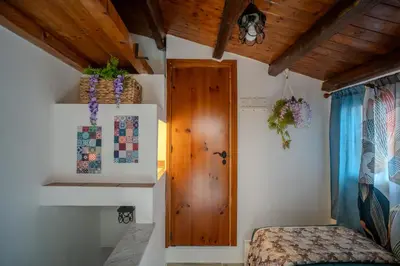 a bedroom with a bed and a wooden door at La Casetta di Dandrì in Monreale