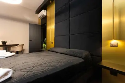 a bedroom with a bed and a desk and a table sidx sidx sidx at Black Room Suite and SPA in Carini