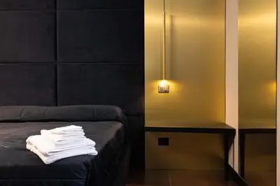 a room with a bed with white towels on it at Black Room Suite and SPA in Carini