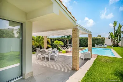 a patio with a table and chairs next to a swimming pool at Oasi delle Nereidi in Alcamo