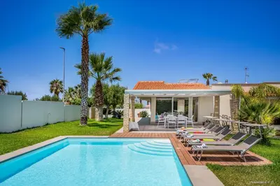 a villa with a swimming pool and a house at Oasi delle Nereidi in Alcamo