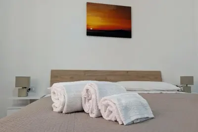 a bedroom with a bed with towels on it at Nonna Rosa Anna in Isola delle Femmine