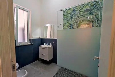 a bathroom with a toilet and a sink and a window at Nonna Rosa Anna in Isola delle Femmine