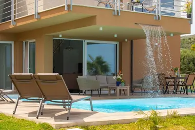 a swimming pool with chairs and a fountain at Villa Soho in Castellammare del Golfo