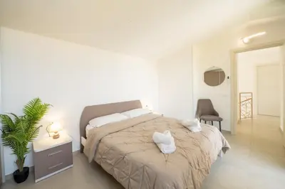 a bedroom with a bed with two towels on it at Villa Soho in Castellammare del Golfo