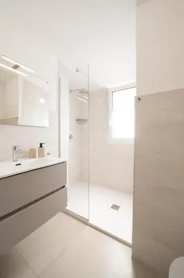 a white bathroom with a shower and a sink at Villa Soho in Castellammare del Golfo