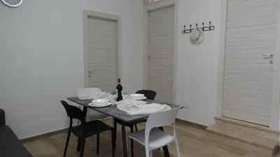 a dining room table with chairs and a bottle of wine at Stella di mare Acquamarine in Balestrate