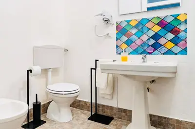 a bathroom with a white toilet and a sink at Piano Imperiale Home in Palermo
