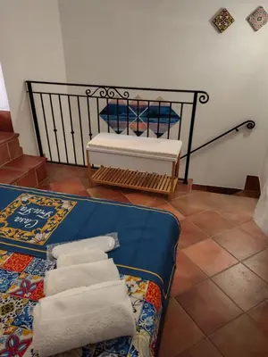 a room with a bench and towels on a rug at Casa Frufa in Terrasini