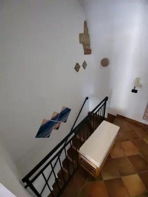 a staircase with a white bench and a wall with art at Casa Frufa in Terrasini