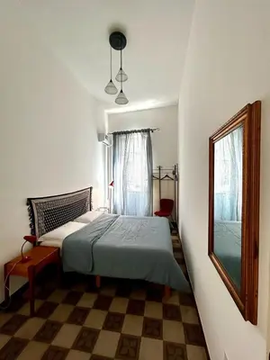 a bedroom with a bed and a window and a mirror at Casa Mediterraneo in Palermo