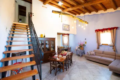 a living room with a staircase and a table and chairs at Rooms Parrinelli in Partinico