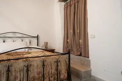 a bedroom with a bed and a window with curtains at Rooms Parrinelli in Partinico