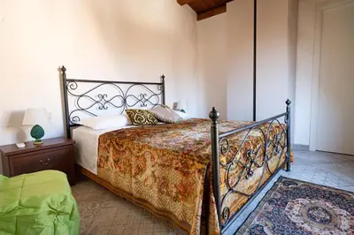 a bedroom with a bed with a wrought iron bed frame at Rooms Parrinelli in Partinico