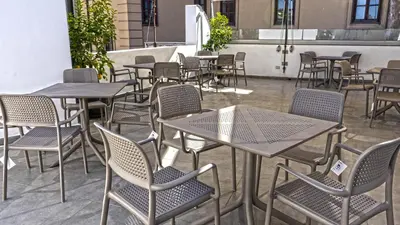 a group of tables and chairs in a patio at Ostello Vucciria in Palermo