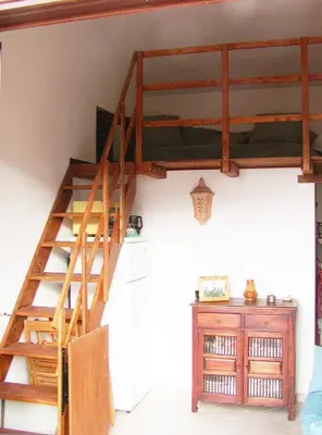 a wooden staircase in a room with a wooden table at Casa panorama in Castelluzzo