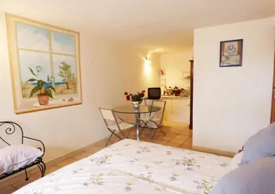 a bedroom with a bed and a table and a window at Casa panorama in Castelluzzo