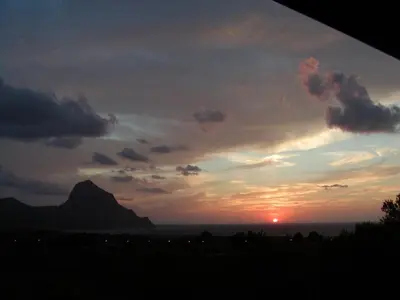 a sunset with a mountain in the background at Casa panorama in Castelluzzo