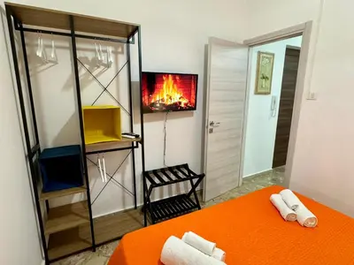 a room with a bed and a fire in the mirror at Beautiful Dimora Anna e Ciccio in Casteldaccia