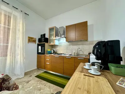 a kitchen with a wooden table and a television at Beautiful Dimora Anna e Ciccio in Casteldaccia