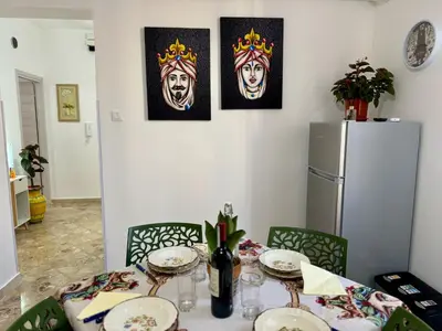a dining room table with plates and a refrigerator at Beautiful Dimora Anna e Ciccio in Casteldaccia