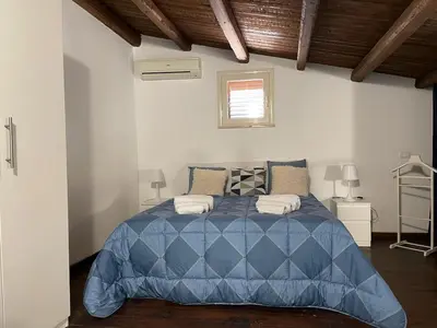 a bedroom with a blue comforter on a bed at Casa di Reginaldo al Capo in Palermo