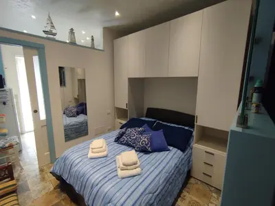 a bedroom with a blue bed and two chairs at Sea Diamond in Santa Flavia