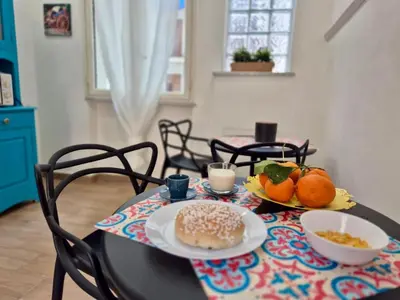 a table with two plates of food and fruit on it at Sicilia Bedda Room's in Palermo