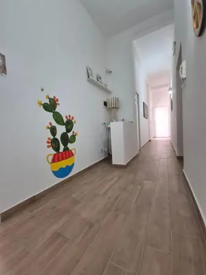 a room with a hallway with a potted plant on the wall at Sicilia Bedda Room's in Palermo