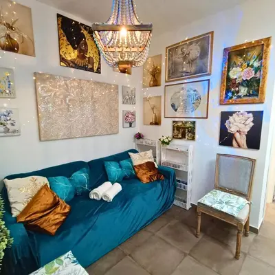 a living room with a blue couch and a chair at Casa Emilia in Palermo