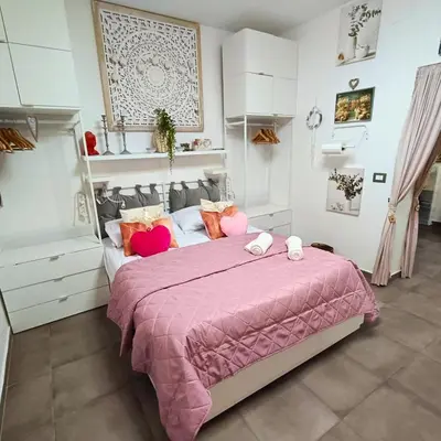 a bedroom with a large bed with pink blankets and pillows at Casa Emilia in Palermo