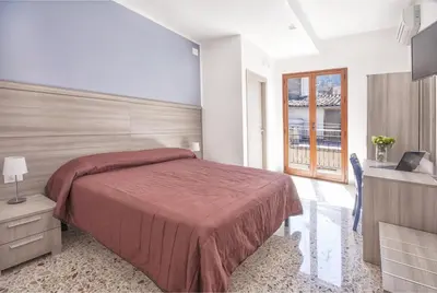 a bedroom with a large bed and a television at B&B La Torre in Castellammare del Golfo