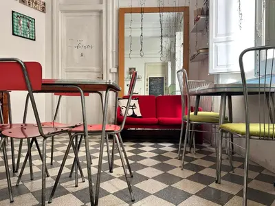 a room with tables and chairs and a red couch at Via Zara Arararooms in Palermo