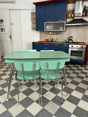 a kitchen with a blue table and two chairs at Via Zara Arararooms in Palermo