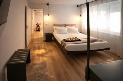 a white bed in a room with a wooden floor at Residenza Ximenes Hub in Palermo