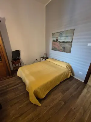 a bedroom with a bed with a yellow blanket at Casa Vacanza Mondello nel Cuore in Mondello