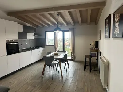 a kitchen with white cabinets and a table and chairs at La Casetta di Gloria in Carini