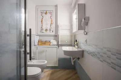 a white bathroom with a sink and a toilet at Pusamonti Central Flat in Palermo