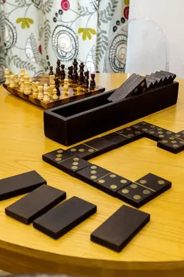 a chess game on a wooden table with black chess pieces at Pusamonti Central Flat in Palermo